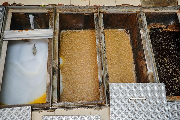 signs that your grease trap needs maintenance include slow drainage, foul odors, and visible grease buildup